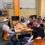 Picture of students sitting around a table, eating, in the Innovation and Collaboration Studio