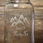 Picture of a Mason jar that has an image of mountains and the phrase "Good Ol' Rocky Top" engraved on the side with a laser cutter, in the Innovation and Collaboration Studio