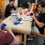Picture of students sitting around a table in the Innovation and Collaboration Studio, working on a project